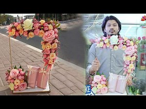 Flowers arrangement in a stand with gift