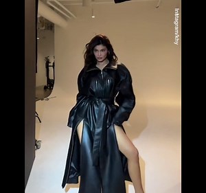 Kylie Jenner puts on a leggy display modeling faux leather trench coat for KHY