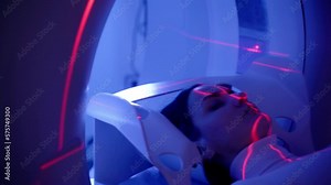 4k video CT x-ray examination of lung cancer with red lines and blue light in medical clinic. Patient girl lies on computed tomography bed and scanning lungs for diagnose lung cancer.