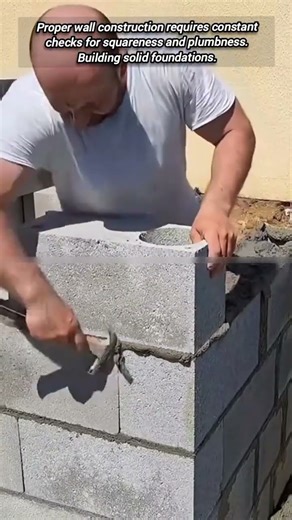 Laying concrete blocks and verifying plumbness for quality.