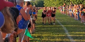 SPASH runners help opposing runner cross the finish line