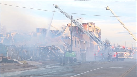 Smoke still rising, crowds gather as firefighters battle day-old 5-alarm apartment blaze