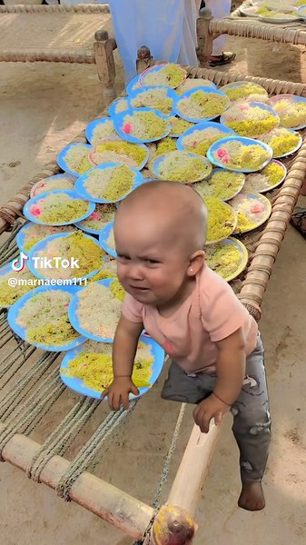 Toddler Explores Colorful Plates at Outdoor Gathering