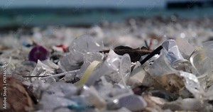 Close-up of a beach polluted with plastic waste. Global environmental disaster, mountains of garbage on the beach that came from the ocean. Empty used dirty plastic bottles and other chemical waste.