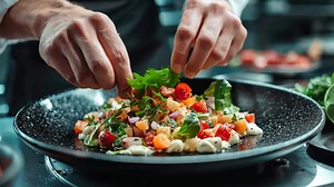 Download A chef is preparing a salad with a variety of vegetables, including tomatoes for free