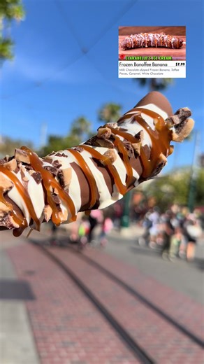 •🍌🍫🍯🌰 Frozen Banoffee Banana – with Toffee Pieces, Caramel Sauce and White Chocolate Drizzle . 💰Price: $7.99 📍Location: 🎡 DCA (‘Clarabelle’s Ice Cream’) Buena Vista Street . 📆 Available: March 6 - April 27, 2026 . . 📝Rating: ✅Delicious . ⚖️ Food Scale Rankings: Absolutely Delicious Really Delicious ✅Delicious Pretty Delicious Really Good Good Pretty Good Ok Bad . . . .