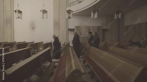 Christian priest in robes walking along church aisle side view tracking shot. Monks in catholic temple. Religious tradition and christianity concept