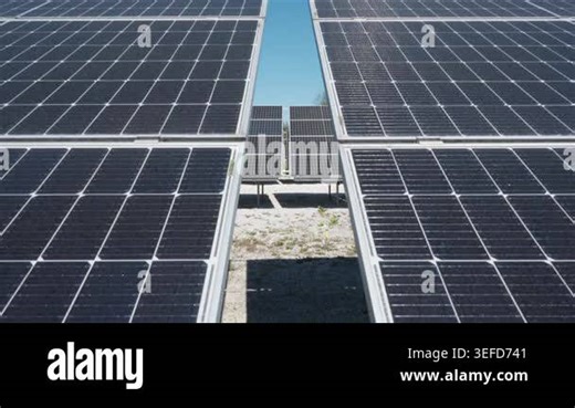 Solar panel array installed in rows at industrial photovoltaic farm. View through modules at renewable energy station for clean electricity production and green technology infrastructure Stock Video Footage - Alamy