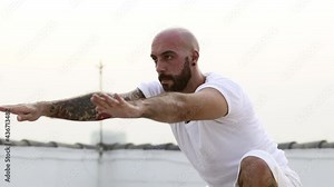 Man Performs Strong Yoga Pose With One Leg While His Arms Are Suspended In Air