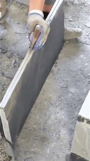 Skilled mason chiseling smooth stone slab edges precisely carefully