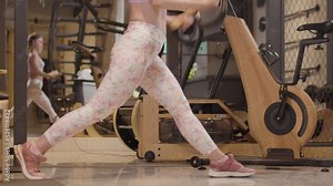 Fit girl execising in a modenr fitness studio. Woman lifing weights in front of mirror..