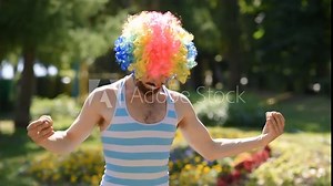 Crazy mime dancing with a castanets in the park. Funny antics and sketch of a clown on the street.