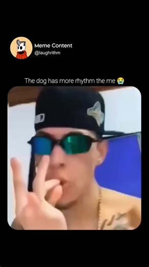 Meme Content on Instagram: "This viral-style meme video features a humorous, chaotic musical duet between a young man and a growling dog, filmed in a close-up, selfie-style format. The man, who is sporting a black backwards baseball cap and reflective green sunglasses, leans in uncomfortably close to the dog's face, which appears to be a Golden Retriever or similar breed. The dog is baring its teeth and emitting a deep, vibrating growl, but instead of backing away, the man utilizes this aggressi