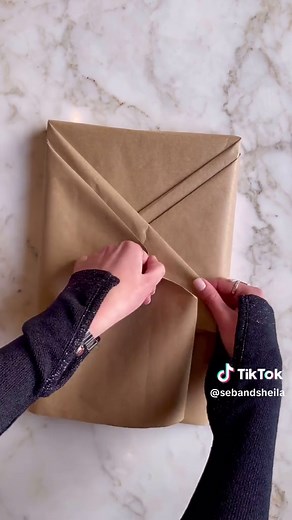 The timeless elegance of brown paper wrapping is rooted in its simplicity and adaptability. Its neutral tone provides a versatile canvas for any occasion, effortlessly complementing various colour schemes. So try this simple gift-wrapping technique and stay tuned all month long for more effortless holiday hosting inspiration. #giftwrapping #bookwrapping #gift #giftideas #diy #diycraft #brown #brownwrappingpaper #brownpaper #eatertainment #eatertainmentthebook #entertainingathome #cookingbook #en