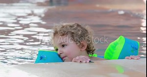 Child wearing inflatable armbands at the swimming pool
