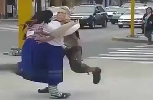 A street performer and his "partner" entertain people walking down the street in Lima, Peru.