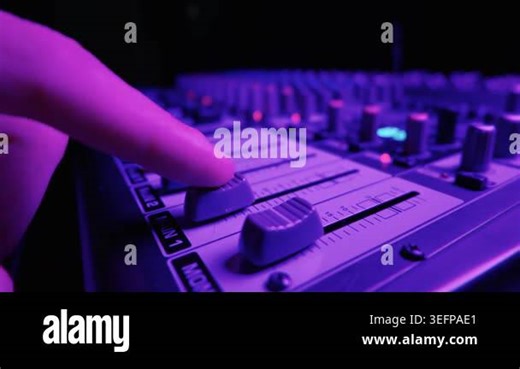 Finger slowly pushes up the volume fader on a professional audio mixing console illuminated by vibrant neon purple studio lighting. Concept of music production and live event sound Stock Video Footage - Alamy