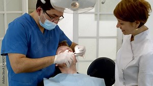 Dental clinic. Doctor dentist treats teeth to the patient in the dental clinic. Dentistry and orthodontist. Dental treatment and bite correction.
