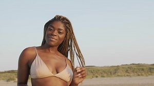Beautiful black model posing at the beach with a bikini set
