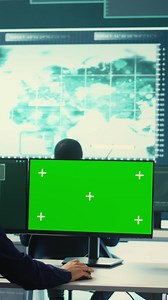 Vertical Governmental hackers using green screen in performing cyber security monitoring and threat detection. Examining network security and protection against cyber attacks, national intelligence. Camera B.