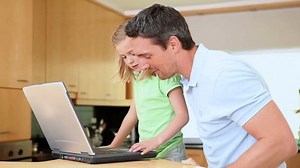 clip-2899072-daughter-using-laptop-while-father-looking-kitchen