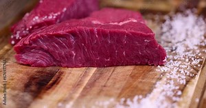 sliced piece of fresh raw beef during salting, preparation of semi-finished products with beef meat with salt
