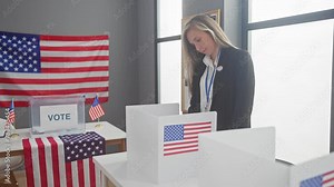 A blonde woman voting at an american polling station with us flags
