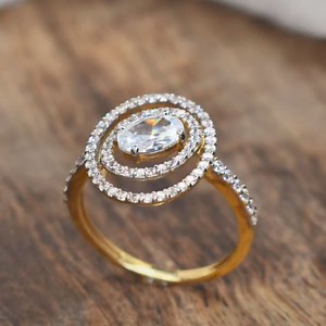 Gold Swarovski Crystal Ring #LavyaJewels #Rings #Swarovski Crafted with precision, this exquisite gold ring is adorned with Swarovski crystals, creating mesmerizing display of light and luxury. The centerpiece features an enchanting oval-shaped Swarovski crystal, embraced by two radiant halos of smaller shimmering crystals. #GoldJewellery #CustomizedJewellery #PersonlalizedJewellery #AffordableJewellery #Lightweight #Jewellery #FashionAccessories #ShineBrightWithLavyaJewels #Trending #Viral #Ree