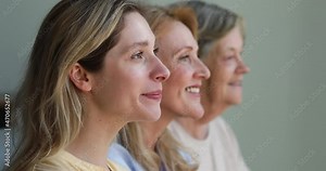 Close up portrait 3 female generations dynasty stand in row smile look away then turn to camera. Profile view of happy healthy young aged and elderly women faces. Ageing process. Genetics and heredity