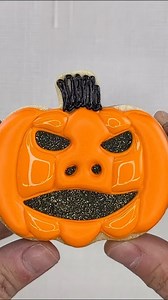 🎃 Creating depth with this Jack-o’-Lantern cookie! Start with a black base, scrape it for texture, add a touch of glitter, and finish by piping the pumpkin sections on top for a sunken-in effect. Perfect for adding that extra detail to your Halloween cookies. #JackOLanternCookies #HalloweenTreats #CookieTechniques #sugarcookietutorial | The Cookie Countess