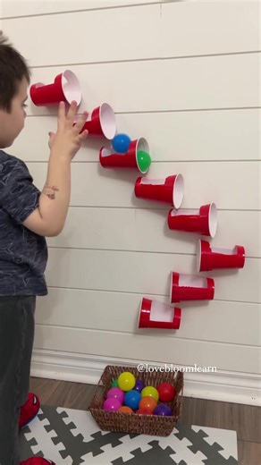 💕🌈Try this DIY BALL RUN! So easy and fun! Click the ✨FOLLOW✨ button to continue learning more! To recreate this activity, make a hole in a red solo cup (you can find tons at the dollar store) and tape it to the wall, creating a “ball run.” We used play balls for the ball run. The kids had a blast! Enjoy! 🤩 ⚠️All activities on this page should be supervised by an adult. ➡️For easy play ideas, check out my Baby and Toddler Caregiver Play & Milestone guides. It’s loaded with tips, milestones & p