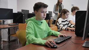Schoolboy using computer during computer sciene lesson in school.