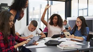 Teacher helping high school students with technology