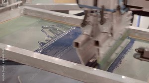 Equipment for serigraphy printing, carousel type - printing on fabric by layers through a stencil, image of different colors. Closeup