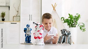 a small child boy plays with robots at home on a mat, a child learns to program and run robots, robotics.