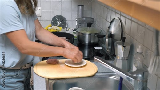 Woman cooking meatballs or meat patties cutlets frying with oil in a pan on the stove. Home cooking, traditional recipes and culinary