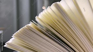 Open book with fanned pages. Stack of hardback paper books on wooden bookshelves. Library bookcase in a row. Books stacking. Back to school. Education, reading moving forward along shelves