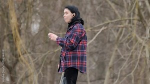 Young woman vaping with an electronic cigarette. Blowing the dense smoke out. Wretched woman. Thoughtful face of a girl looking into the distance in the open air.