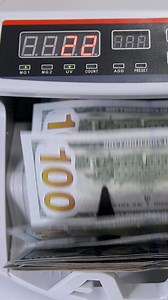 Automatic money counting in the machine. Electronic money machine is counting the dollar banknotes. Front view. Close-up. Vertical