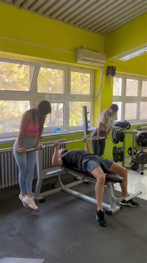 Intense Bench Press Session with Spotters in the Gym