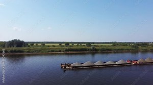 Concept of river cargo transportation development. A tug with a large barge goes along the river. Aerial video from the drone . High quality 4k footage.