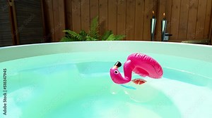 Fallen over inflatable flamingo drink holder and decorations floating in hot tub