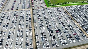 From above, a lineup of the latest car models creates an artful mosaic of shapes and colors. The drone's perspective reveals the perfect symmetry and precision in their arrangement.