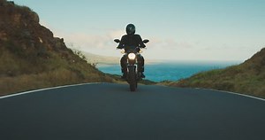 clip-1026135182-motorcyclist-riding-fast-on-country-road-ocean