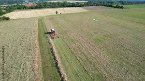 Rowing of the mown silage crop by a tractor in lines. Preparation of fodder for cattle for the winter. Top view.