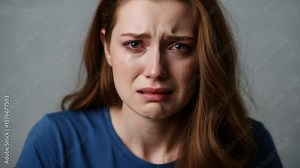 Close-up of a distraught young woman crying with tears streaming down her face, conveying deep sadness, grief, and emotional pain