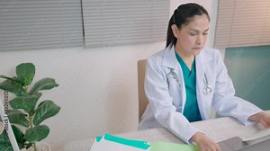 Female doctor using computer working at clinic or hospital Doctor typing on computer talking with patient to help give advice and explain illness.