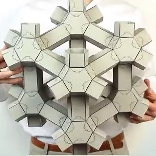 Harvard SEAS prismatic architected metamaterial: extruded cubic cells (24 faces, 36 edges) tessellated via snapology origami. Reconfigures volume, shape, and effective stiffness on demand through hinge folding; scale-independent from nano to meter.