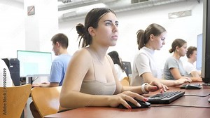 Smart Latin female teenager learning computer science while she is using a PC in the computer classroom