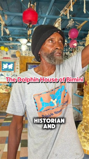 Most people who come to Bimini notice the water first. It’s impossible not to. But if you spend a little more time here, you start to notice the people — and the stories they’ve been carrying for generations. Sir Ashley Saunders is one of them. A local historian, poet, and what he calls a “dolphin-inspired artist,” he’s spent more than three decades building the Dolphin House by hand using recycled materials he’s collected across the island. But the house is really just an entry point. Because o